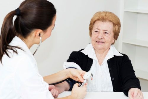 Geriátrico La Panoya enfermera midiendo presión a mujer mayor